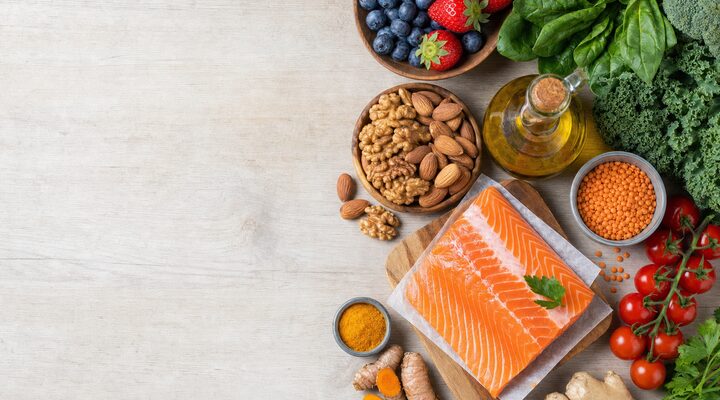 Anti-inflammatory whole foods: salmon, leafy greens, berries, olive oil, nuts, turmeric and lentils