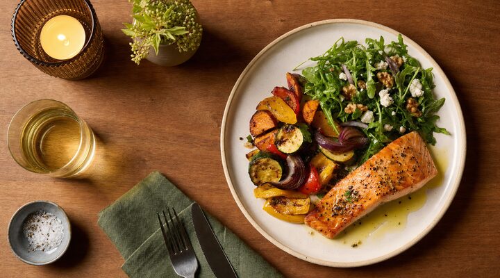 Anti-inflammatory dinner plate with roasted salmon, roasted vegetables and leafy green salad