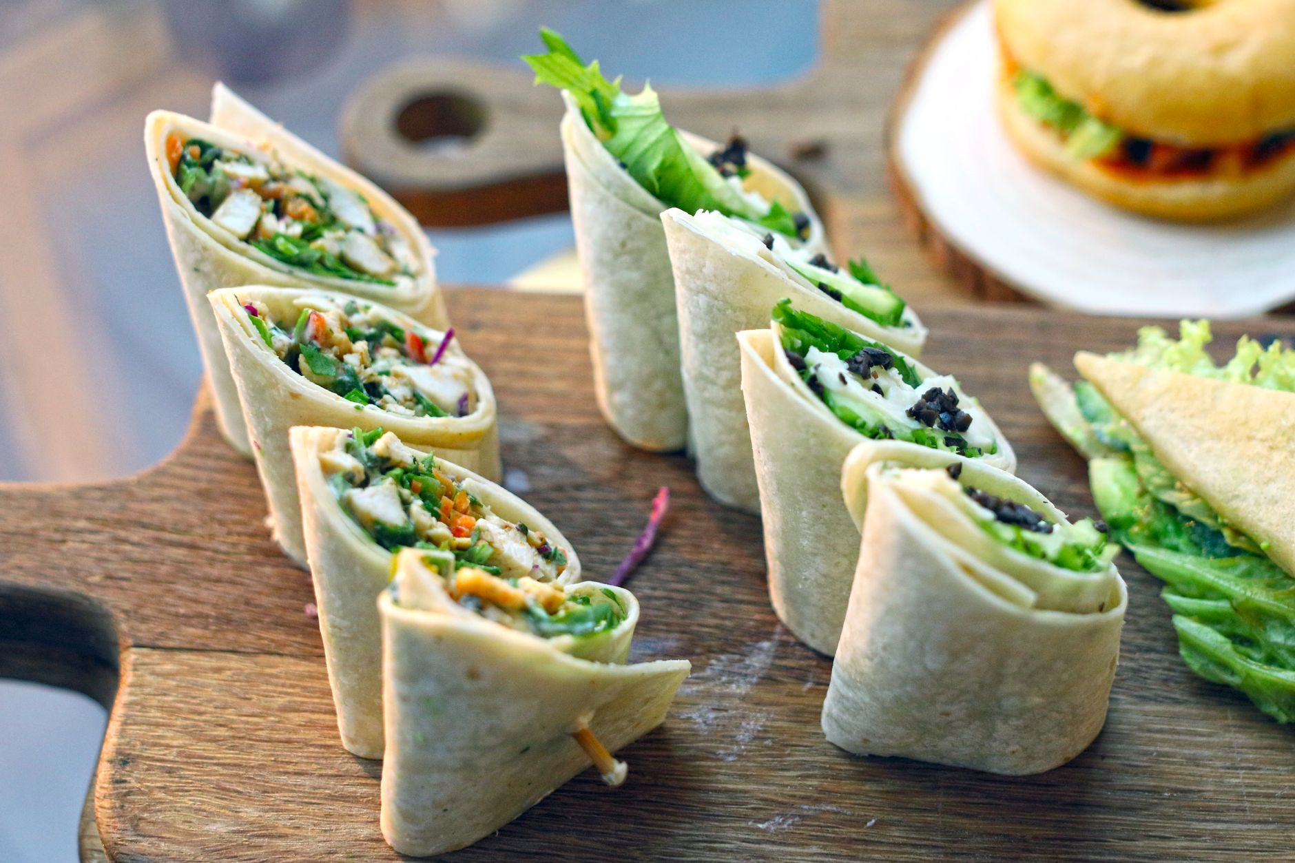 Vegetable wraps filled with leafy greens on a wooden board