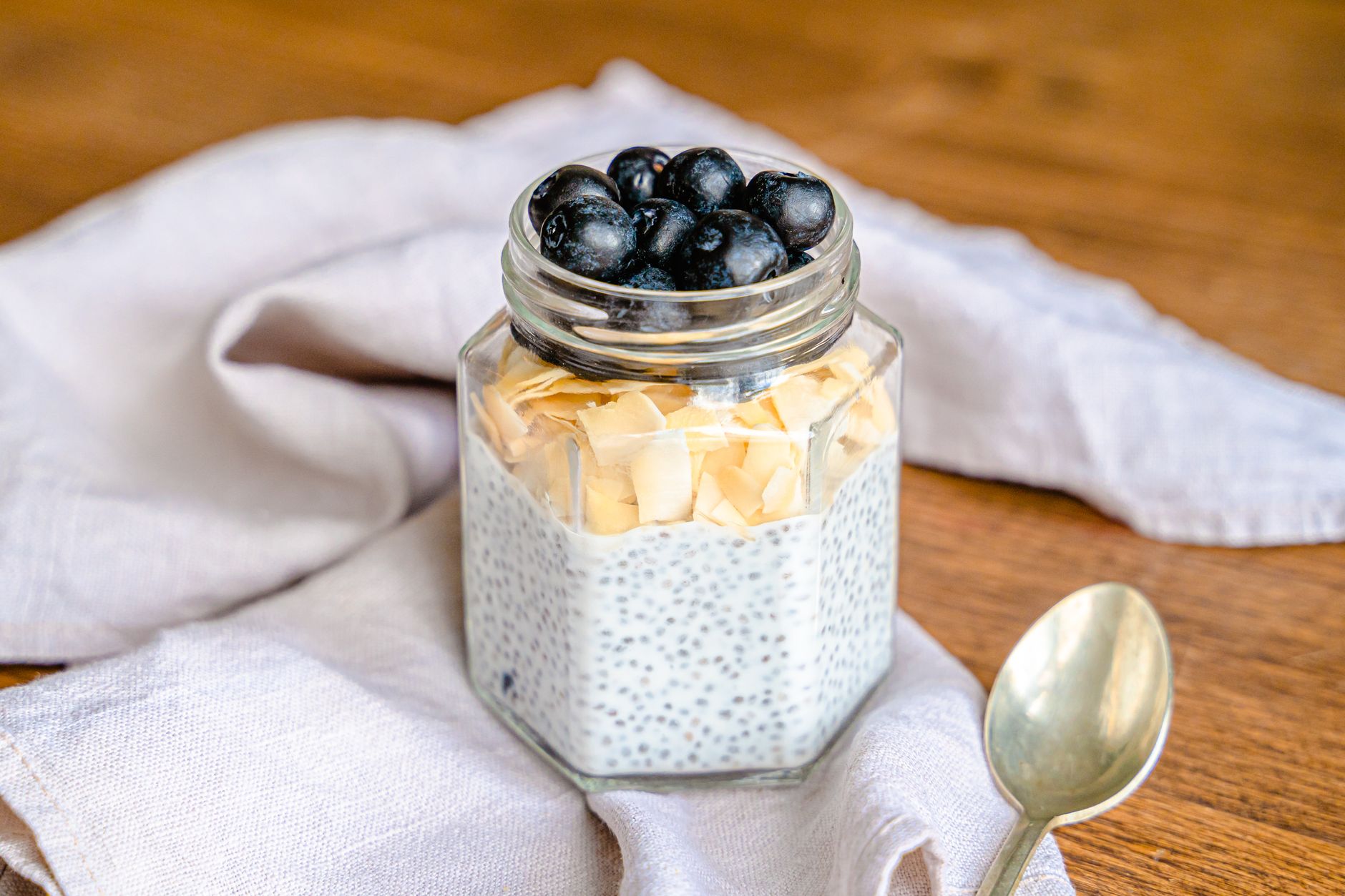 Make-ahead chia pudding jar topped with blueberries and coconut