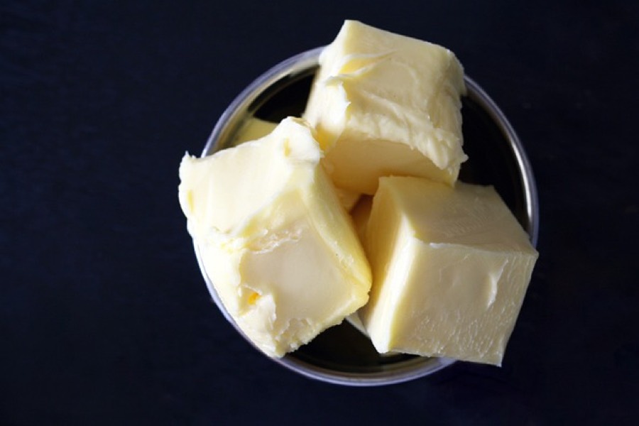 Chunks of butter in a small dish on a dark background
