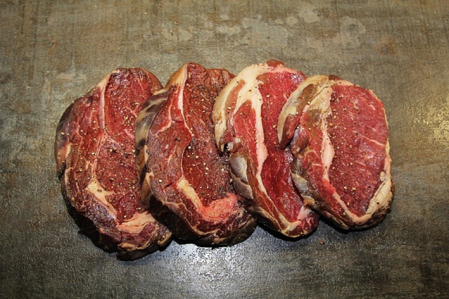 Raw beef ribeye steaks showing fat marbling