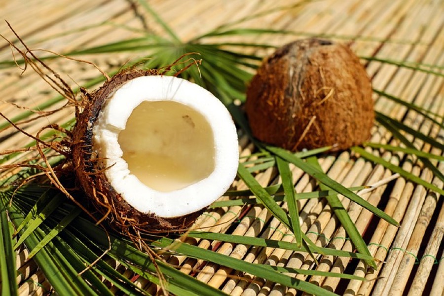 Fresh coconut cracked open showing the white flesh inside the brown shell