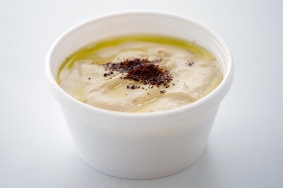 Bowl of hummus drizzled with olive oil and dusted with sumac
