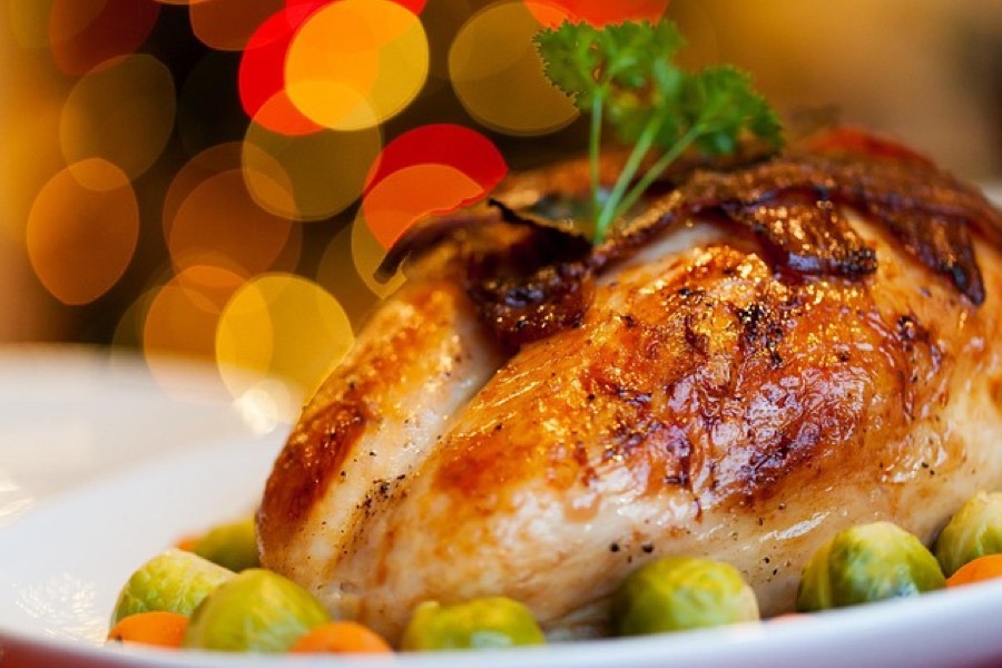 Roast turkey breast on a white plate with brussels sprouts and carrots