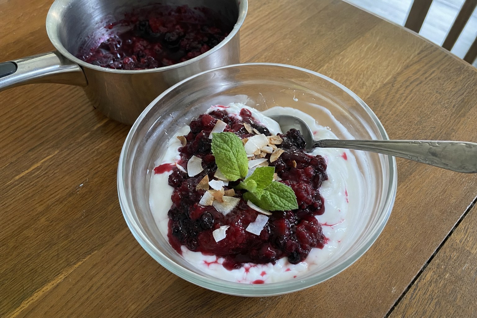 AIP coconut yogurt bowls topped with warm berry compote, toasted coconut curls and fresh mint